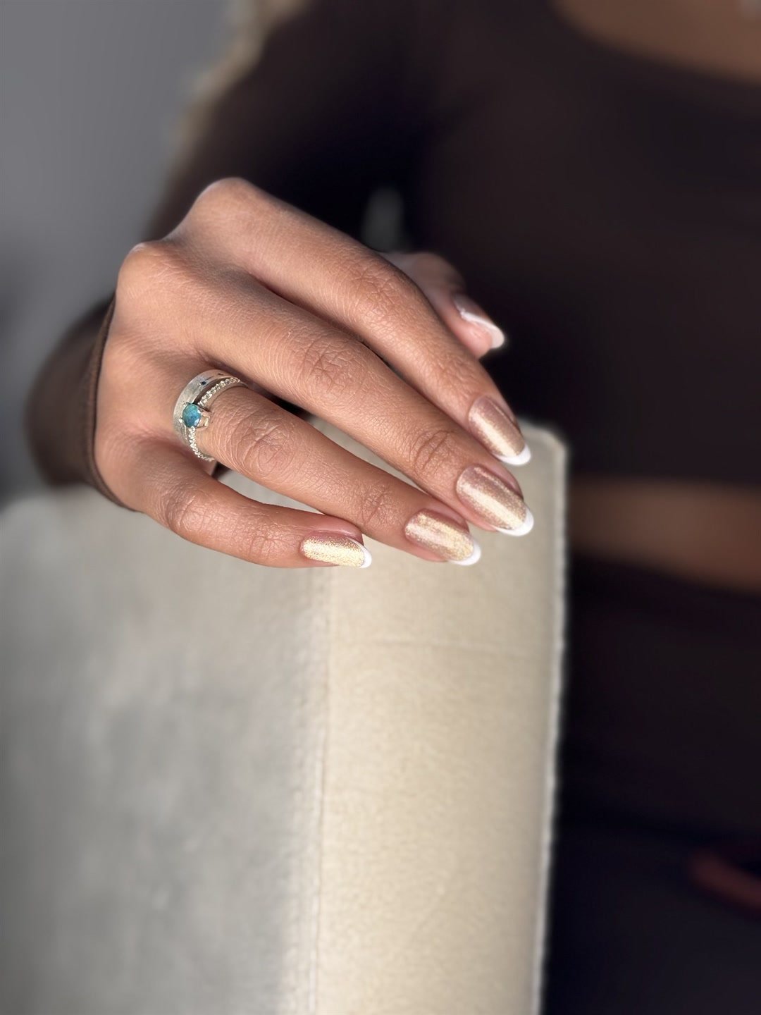 Mão com unhas em gel nude e ponta branca, estilo francesinha